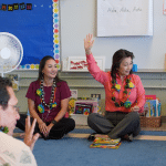 adults and children sitting in classroom