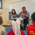 Lt. Gov. Sylvia Luke with a legislator holding a book sitting in front of pre-K students in a Ready Keiki classroom.