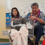 Lt. Gov. Sylvia Luke with a legislator holding a book sitting in front of pre-K students in a Ready Keiki classroom.