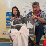 Lt. Gov. Sylvia Luke with a legislator holding a book sitting in front of pre-K students in a Ready Keiki classroom.